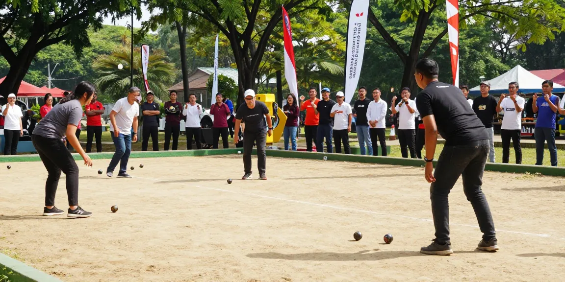 Pertandingan petanque yang meriah di fopikotatarakan.org, pemain beragam berkompetisi di lapangan, penonton bersemangat.